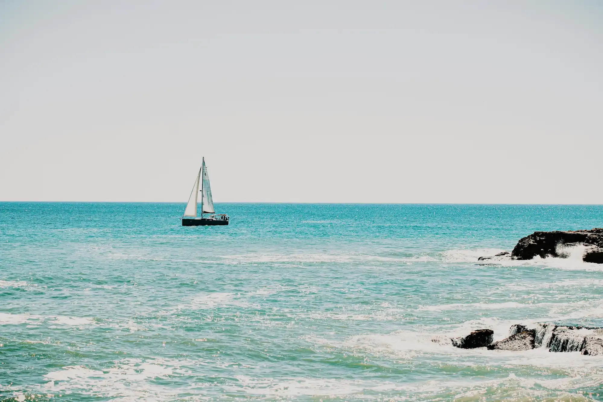 Vista del mar con un barca en un día soleado